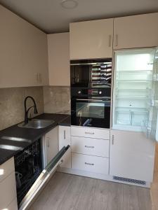 eine Küche mit weißen Schränken und einer Spüle in der Unterkunft Vieno kambario butas Šiauliuose in Šiauliai