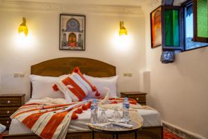 una camera da letto con un letto a cigno sopra di Riad Dalla Fes a Oulad Akkou Altre 71 foto