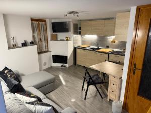 a kitchen and a living room with a couch and a table at Stone Nest Lanzada in Lanzada