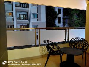 - un balcon avec 2 chaises et une table dans l'établissement Hotel Vilaari Blue Marina, à Visakhapatnam