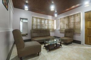 a waiting room with two chairs and a glass table at Collection O Police Bazar Shillong Formerly Pillars House in Shillong +61 photos