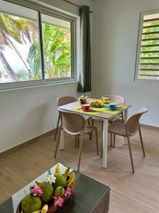 a table with a bowl of fruit on a table at Bord de Mer, Coco Fare Beach, Tahiti in Punaauia