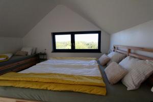 een slaapkamer met een groot bed en een raam bij Kuća za odmor MIRINA in Aljmaš