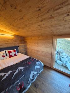 a bedroom in a log cabin with a bed and a window at Le Raidillon Verbier in Verbier