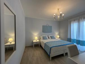 a bedroom with a bed and two tables and a mirror at Domu Jole B&B in Selargius