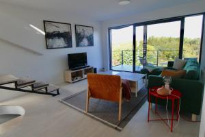 een woonkamer met een bank en een tv bij Kuća za odmor MIRINA in Aljmaš