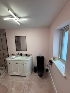 a bathroom with a white sink and a mirror at Boycott House in Shalstone