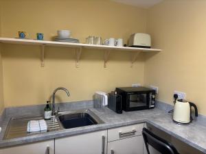 a kitchen with a sink and a microwave at Boycott House in Shalstone