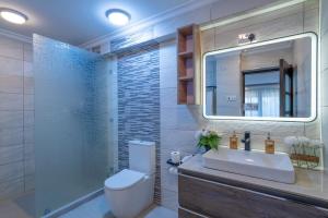 a bathroom with a toilet and a sink and a mirror at SuCasa Villa located in Maiyan Luxury Resort, Nanyuki in Nanyuki +22 photos