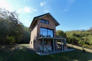 een stenen huis met een balkon en een tafel en stoelen bij Kuća za odmor MIRINA in Aljmaš