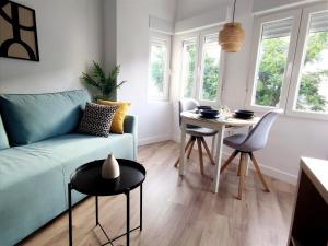 Una sala de estar con un sofá azul y una mesa. en Apartamento-loft - Rincón de Belén, en Jaén