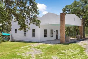 an old white house with a brick chimney at Hill Country RelaxStation Getaway in Morris Ranch
