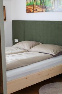 Cama en habitación con pared verde en Apartment Wörer, en Perca 13 fotos más