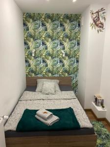 una camera da letto con un letto con una coperta verde di EM Room a Cracovia