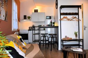 a living room with a couch and a kitchen at Studio Castéra 1 Air-conditioned in Bègles
