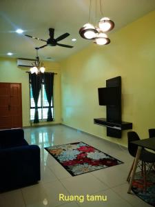 a living room with a couch and a rug on the floor at Afwan homestay klebang melaka in Melaka