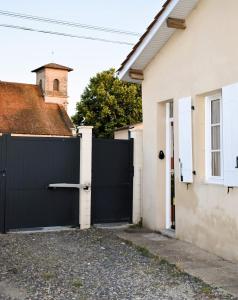 a black garage door in a white house at Studio Castéra 1 Air-conditioned in Bègles