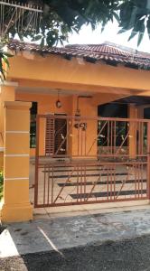 a small house with a gate and a balcony at Afwan homestay klebang melaka in Melaka