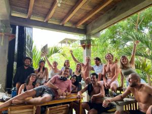 a group of people sitting at tables with their hands in the air at Hermanos Perdidos Surf in Las Tunas