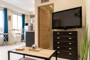 a living room with a television on top of a dresser at Studio Tamaris au coeur historique de Montauban in Montauban