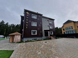 a building with a sign on the side of it at Avenue Boutique Hotel in Borovoye