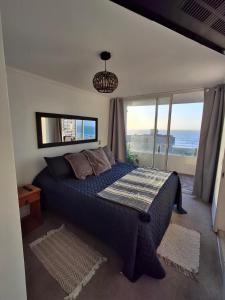 a bedroom with a bed with a view of the ocean at Excelente departamento a 150 metros de la playa en La Serena in La Serena