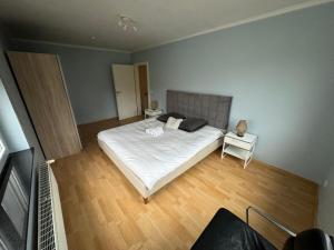 a bedroom with a large white bed and a wooden floor at Green escape - Sunset & nature in Boevange-sur-Attert