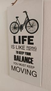 un cartel en una pared con una bicicleta. en NOMAD Hostel Stone Town, en Zanzíbar