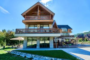 a large house with a balcony on top of it at TATRA SUITES Vila HIMALAYA in Tatranská Lomnica