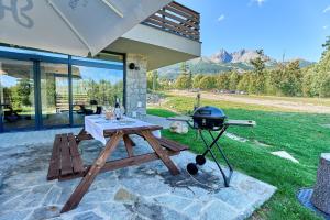 a picnic table with a grill on a patio at TATRA SUITES Vila HIMALAYA in Tatranská Lomnica