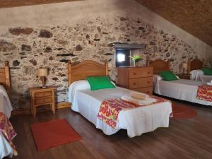 a bedroom with two beds and a stone wall at El Almendro del Cura in Villarmayor +41 photos