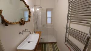 a white bathroom with a sink and a shower at 0.3 Stanze in Trieste +23 photos