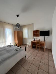 a bedroom with a bed and a desk and a television at B&B Pokerdassi in Leonforte