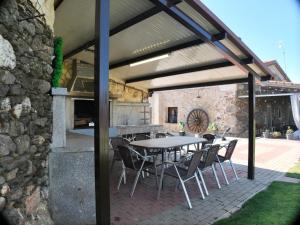 a patio with a table and chairs and a stone wall at El Almendro del Cura in Villarmayor