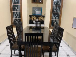 a dining room with a glass table and chairs at Nakwa's mansion in Malpe
