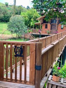 a wooden bridge with a house in the background at Cabaña de lujo con Lavadora y Secadora - Caballo Dorado in Guarne