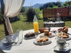 a table with plates of food and a bottle of orange juice at Cabaña Emmanuel in Santa Rosa de Calamuchita