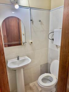 a bathroom with a toilet and a sink and a mirror at Casa Calamo Hotel in Treinta y Tres