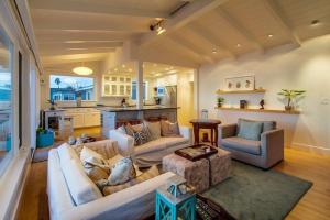 a living room with white couches and a kitchen at Sunset Beach in Encinitas