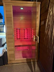 eine Glastür mit rosa Lichtern in einem Zimmer in der Unterkunft Glamping & wellness Moonlight in Brakel