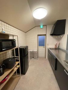 a small kitchen with a refrigerator and a microwave at Family friendly Hotel - Free Parking,Tokyo Disney & Narita Airport in Matsudo