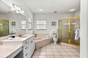 a bathroom with two sinks and a tub and a toilet at Villa Champagne - 5322 in Siesta Key +83 photos