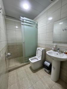 a bathroom with a toilet and a sink and a shower at Old Saroy Hotel in Samarkand
