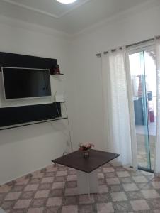 a living room with a table and a microwave at Varanda palmeiras in Cabo Frio