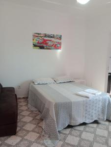 a bedroom with a bed and a picture on the wall at Varanda palmeiras in Cabo Frio +10 photos