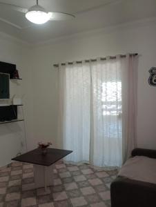 a living room with a table and a window at Varanda palmeiras in Cabo Frio