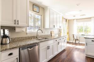 a kitchen with white cabinets and a sink at Wine Country Private Backyard and Bocci Ball in Atascadero