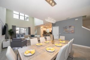 a dining room and living room with a table and chairs at 2744HM VILLA 5 BED/5 BA (SANITIZED) in Kissimmee