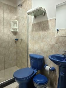 a bathroom with a blue toilet and a shower at hotel san nicolas colonial in Barranquilla