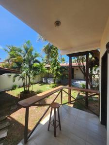 a wooden bench on a porch with a view of a yard at Pipa Villa Mar in Pipa